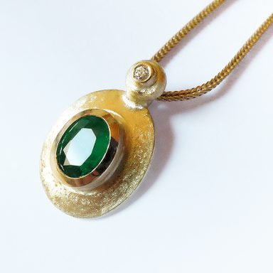 Ovaler Smaragd Anhänger mit kleinem Brillant an einer Goldkette