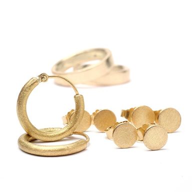 Creolen-Ohrringe und mehrere kleine, runde Ohrstecker aus Gold