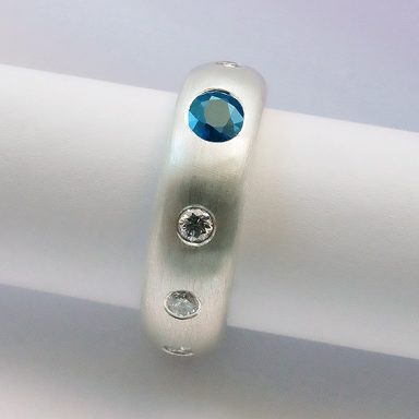 Runder Silberring mit eingefassten Brillanten und blauem Saphir